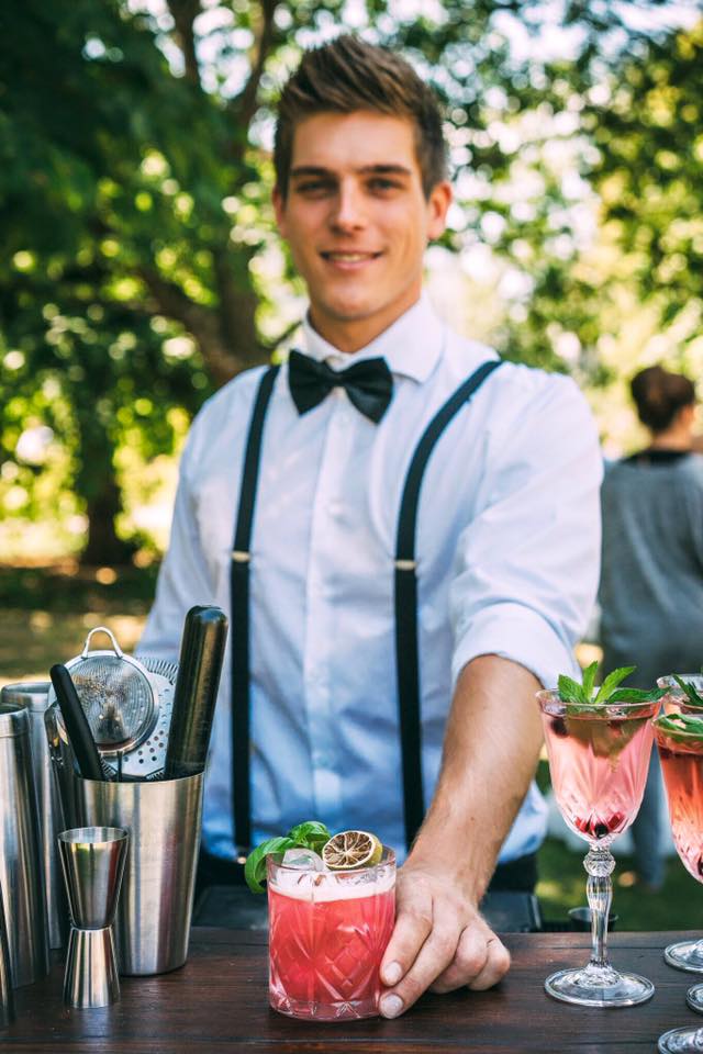 Ein Barkeeper der Barmänner mit einem erfrischenden Cocktail auf einer Party.