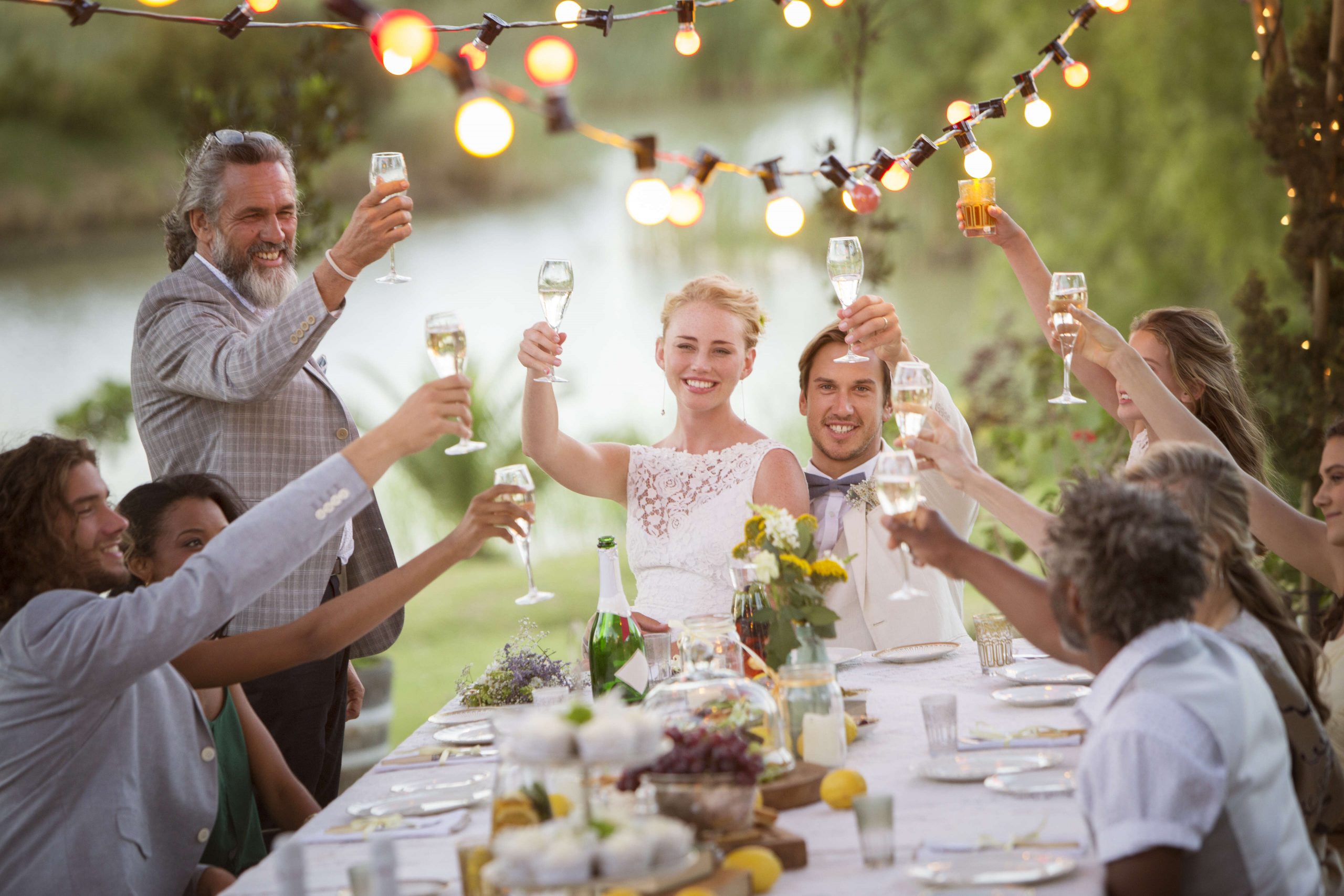 Hochzeitsfeier mit glücklichen Gästen im Freien und Sektempfang von Barmännern im Quadrat